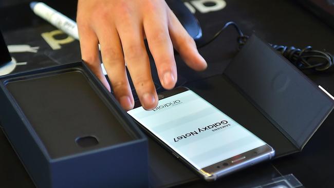 An employee provides a replacement Samsung Galaxy Note7 smartphone at a telecommunications shop in Seoul. Both original and replacement Note7 smartphones have since been recalled.