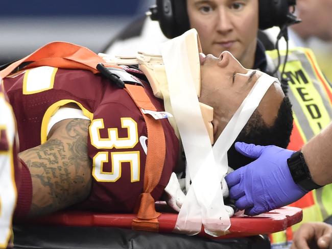Washington Redskins' Dashaun Phillips (35) is carted off the field by first responders as Ricky Jean Francois (99) watches in the first half of an NFL football game against the Dallas Cowboys, Sunday, Jan. 3, 2016, in Arlington, Texas. Phillips was injured while helping stop Cowboys running back Darren McFadden on a running play. (AP Photo/Michael Ainsworth)