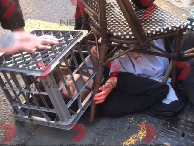 The young man is stopped in his tracks with a chair and a milk crate. Picture: Seven News