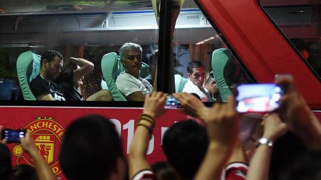Manchester United coach Jose Mourinho (top C) looks at fans from the team bus.