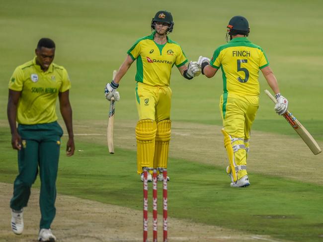 Australia's Steven Smith and Australia's Aaron Finch (C) fist pump after playing a shot during the first T20 international cricket match between South Africa and Australia. Picture: Christiaan Kotze/AFP