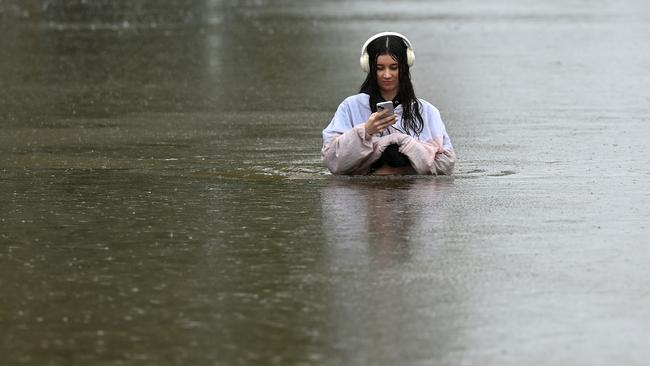 A resident walks on the flooded waters of Edmonstone Street in the suburb of Newmarket. (Photo by Albert Perez/Getty Images)