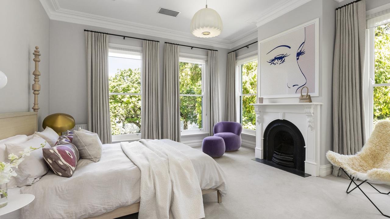 Floor to ceiling windows feature in the bedroom, along with a fireplace.