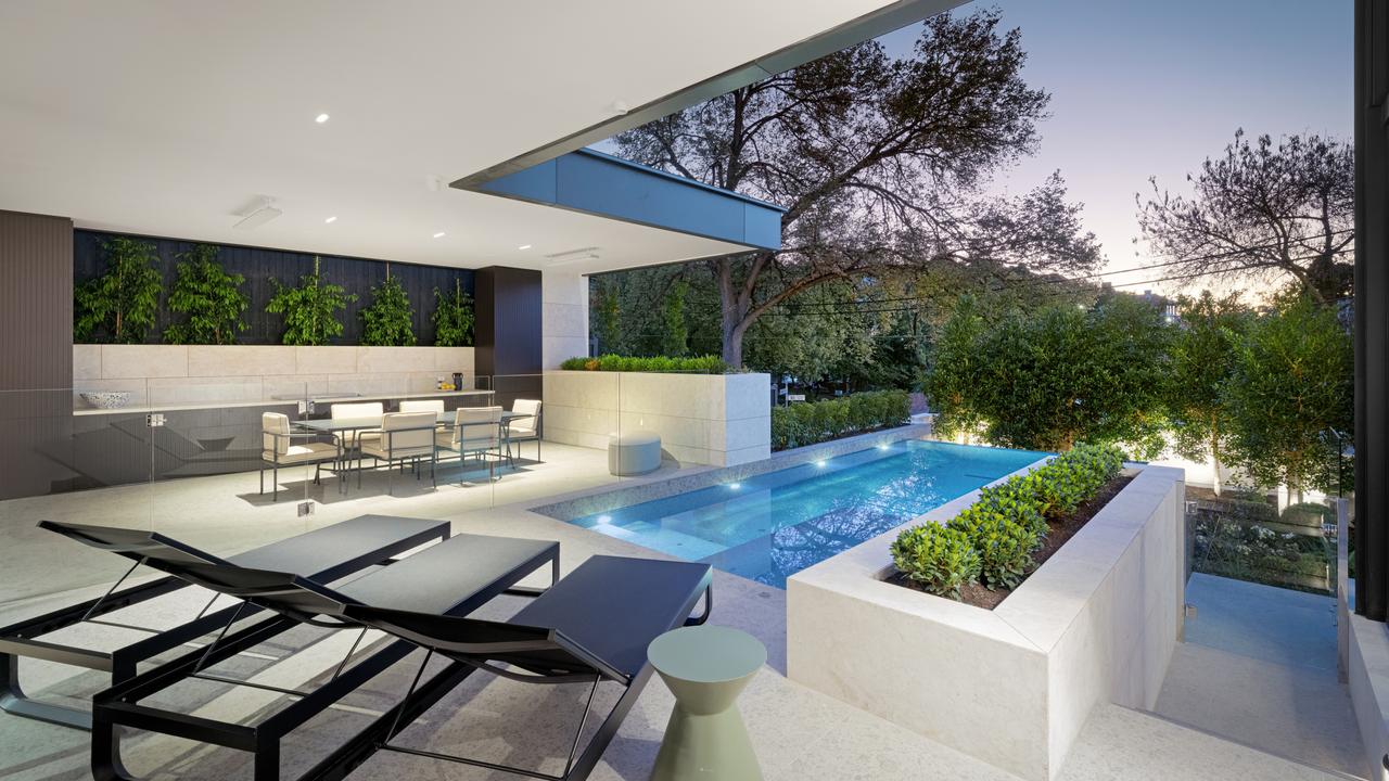 The Toorak home’s infinity-edge pool is framed by manicured landscaping and designed for resort-style entertaining.