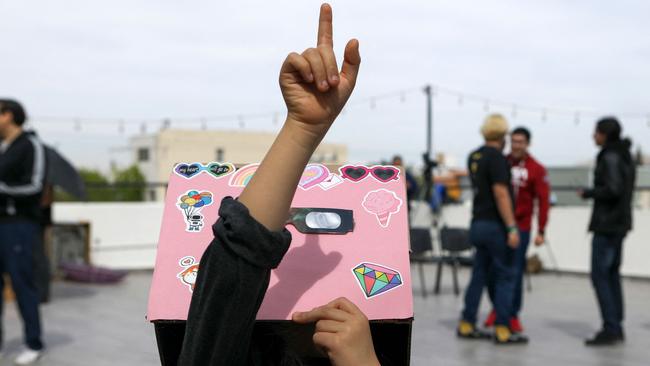 A girl looks and points toward the sky as the moon begins to partially eclipse the sun in Ciudad Juarez, Chihuahua State, Mexico. The Moon’s shadow caused total darkness in Mexico’s Pacific coast. Picture: HERIKA MARTINEZ / AFP)