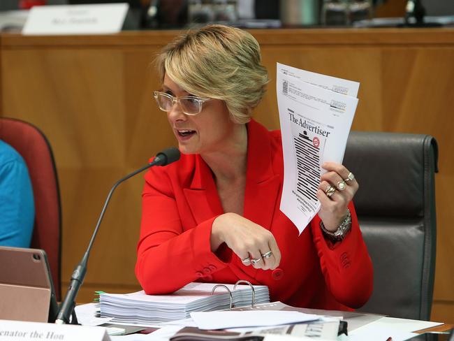 Kristina Keneally holding up the front pages of the papers as she asks questions at a Senate Estimates hearing. Picture: Kym Smith