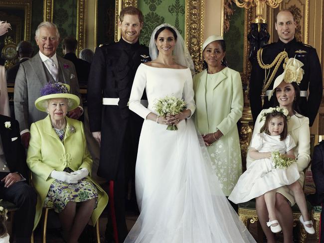 In this photo released by Kensington Palace on Monday May 21, 2018, shows an official wedding photo of Britain's Prince Harry and Meghan Markle, center, in Windsor Castle, Windsor, England, Saturday May 19, 2018. Others in photo from left, back row, Jasper Dyer, Camilla, Duchess of Cornwall, Prince Charles, Doria Ragland, Prince William; center row, Brian Mulroney, Prince Philip, Queen Elizabeth II, Kate, Duchess of Cambridge, Princess Charlotte, Prince George, Rylan Litt, John Mulroney; front row, Ivy Mulroney, Florence van Cutsem, Zalie Warren, Remi Litt. (Alexi Lubomirski/Kensington Palace via AP)