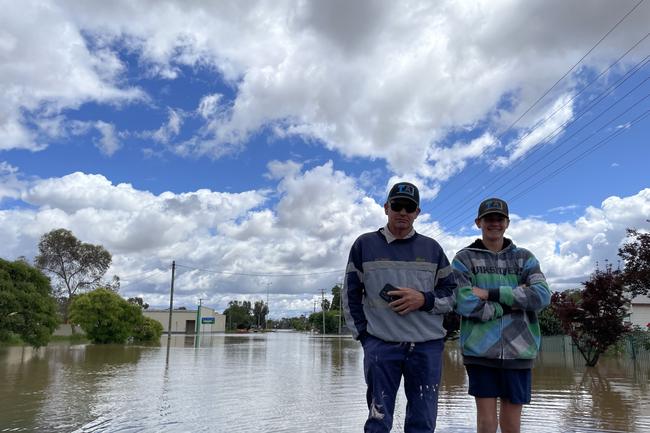 Gary and Jake Tomlinson survey the floodwaters outside their home in Forbes. Picture: Aymon Bertah