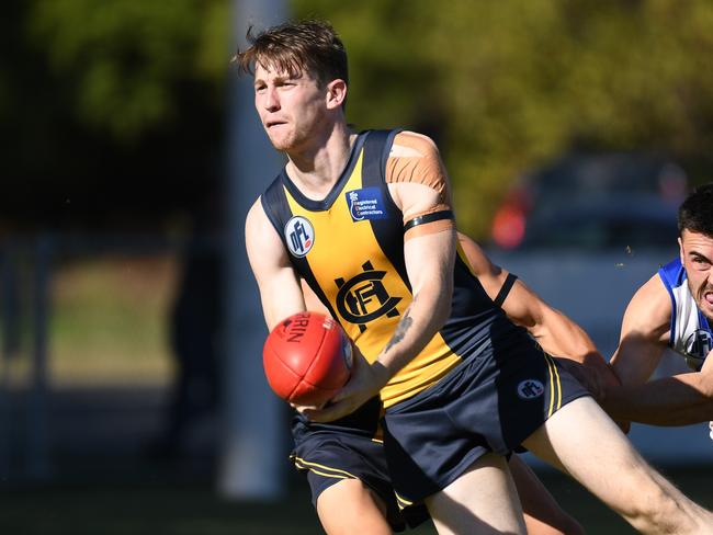 Tom Grimes dishes off a handball for Hurstbridge. Picture: Nathan William Media