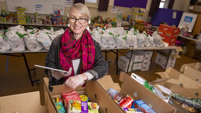 Reservoir Neighbourhood House chief executive Angie Davidson with some of the food hampers that Feed Victoria partner UBER will help deliver. Picture: WAYNE TAYLOR