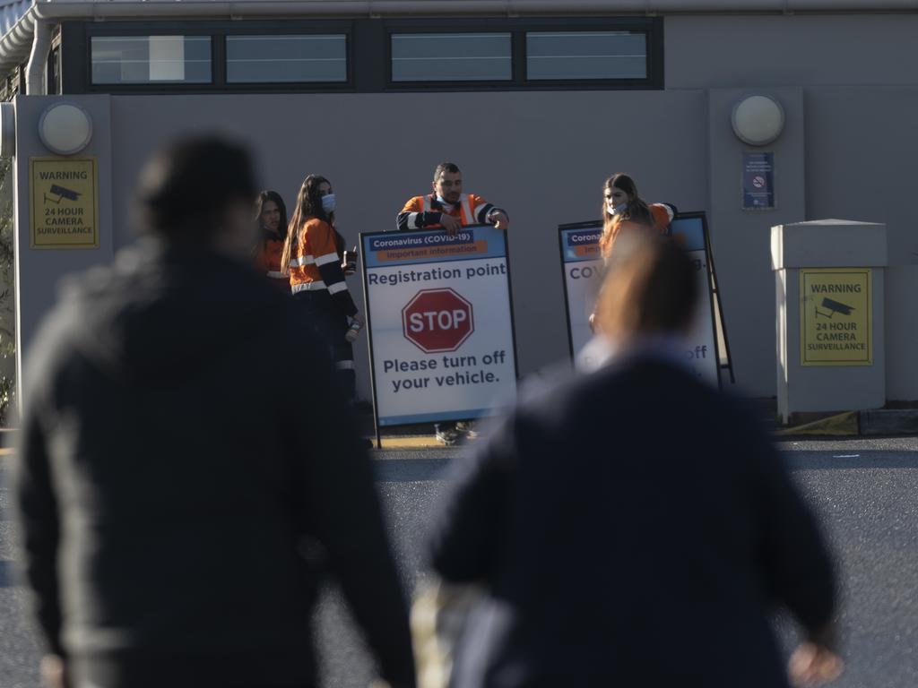 Health workers arrive before COVID-19 testing is carried out at the Crossroads Hotel in the south-west Sydney suburb of Casula. Picture: Brook Mitchell