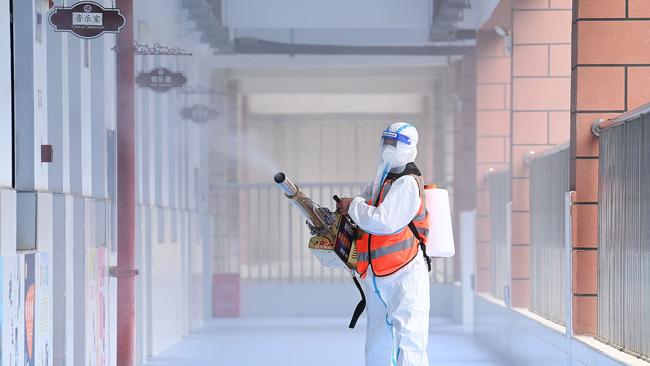 A staff member sprays disinfectant at a primary school in Wuhan. Picture: AFP