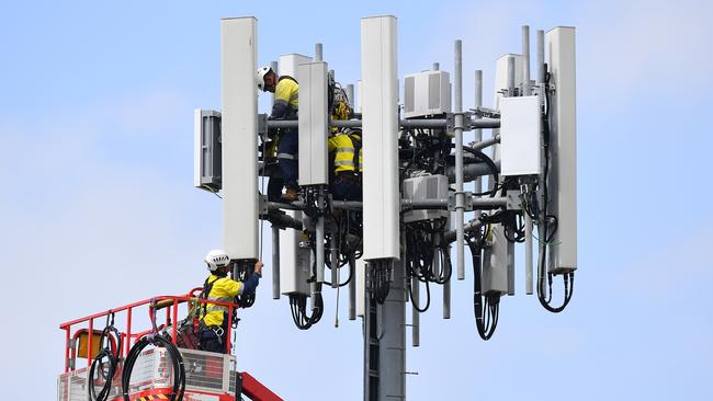 Telecommunications workers are seen working on a mobile cell tower at West Ryde, in Sydney, March 25, 2020. (AAP Image/Dan Himbrechts)