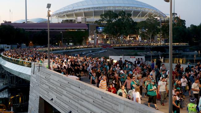 Fans head across the Torrens footbridge after the first AFL match at Adelaide Oval in 2014. Picture: Calum Robertson