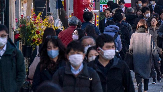 People make their way along a sidewalk in Tokyo on February 17, 2025. Japan's economic growth slowed sharply in 2024, cabinet office data showed on February 17, although the rate for the fourth quarter beat market expectations thanks to strong exports. (Photo by Kazuhiro NOGI / AFP)