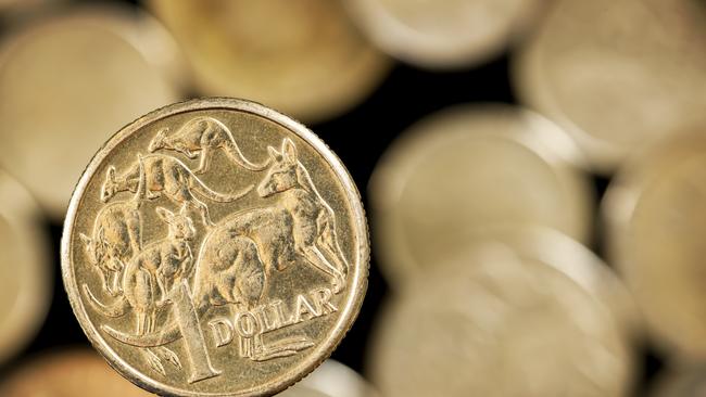 Australian one dollar coin over blurred golden background.