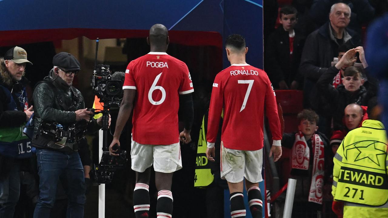 Manchester United's French midfielder Paul Pogba (L) and Manchester United's Portuguese striker Cristiano Ronaldo (R) leave straight after the final whistle in the UEFA Champions League round of 16 second leg football match between Manchester United and Atletico Madrid at Old Trafford stadium in Manchester, north west England on March 15, 2022. - Atletico won the game 1-0, and the tie 2-1 on aggregate. (Photo by Paul ELLIS / AFP)