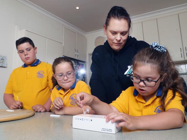 Kelly Halliwell and her kids Ethan (Grade 4) and twins Mayer and Pippa (Grade 2) doing RAT tests before returning to term one of school. Picture: David Crosling