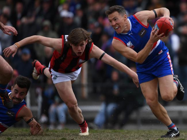 Stephen Dinnell slips the clutches of Mackenzie Doreian. Picture: James Ross/AAP