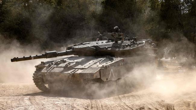 A Merkava tank rolls into position outside Kibbutz Beeri near the border with the Gaza Strip. Picture: Getty