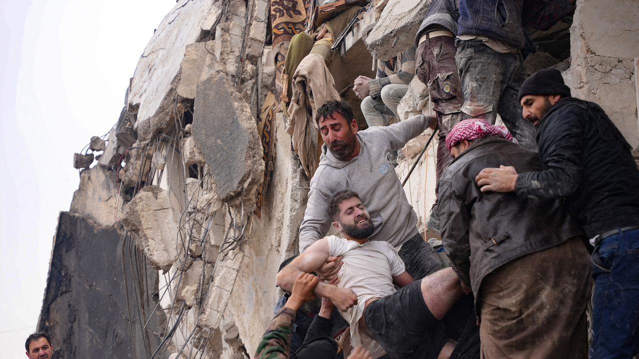 Residents retrieve an injured man from the rubble of a collapsed building following an earthquake in the town of Jandaris, in the countryside of Syria's northwestern city of Afrin in the rebel-held part of Aleppo province, on February 6, 2023. - Hundreds have been reportedly killed in north Syria after a 7.8-magnitude earthquake that originated in Turkey and was felt across neighbouring countries. (Photo by Rami al SAYED / AFP)