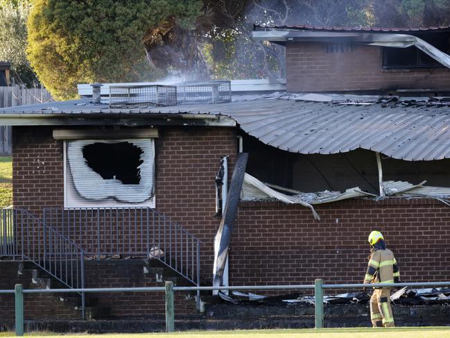 Fire crews outside the badly damaged sports club after the fire. Picture: David Crosling