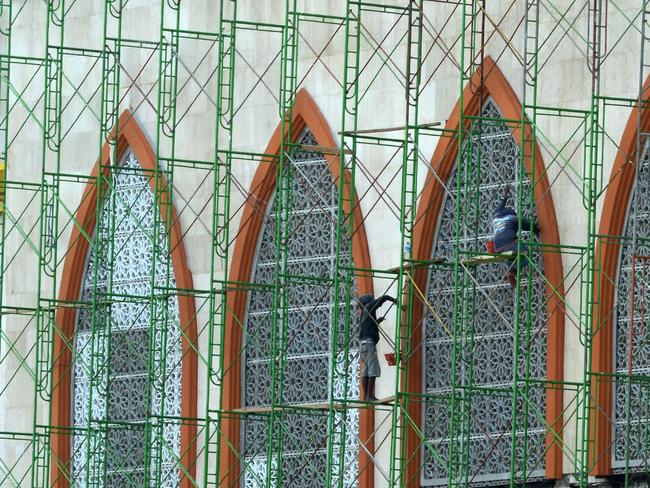 Workers paint an Islamic centre in Mataram as the island prepares to boost its visitors from wealthy Middle Eastern countries. AFP PHOTO / SONNY TUMBELAKA