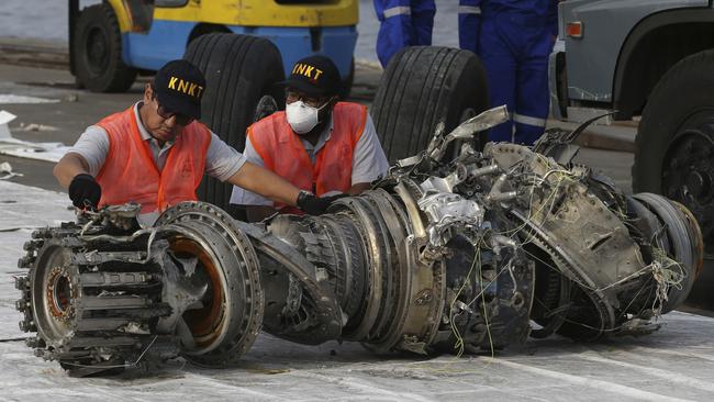 Officials inspect an engine recovered the crashed Lion Air jet in Jakarta, Indonesia, Sunday, Nov. 4, 2018. The brand new Boeing 737 MAX 8 jet plunged into the Java Sea just minutes after takeoff from Jakarta early on Oct. 29, killing all of its passengers on board. (AP Photo/Achmad Ibrahim)