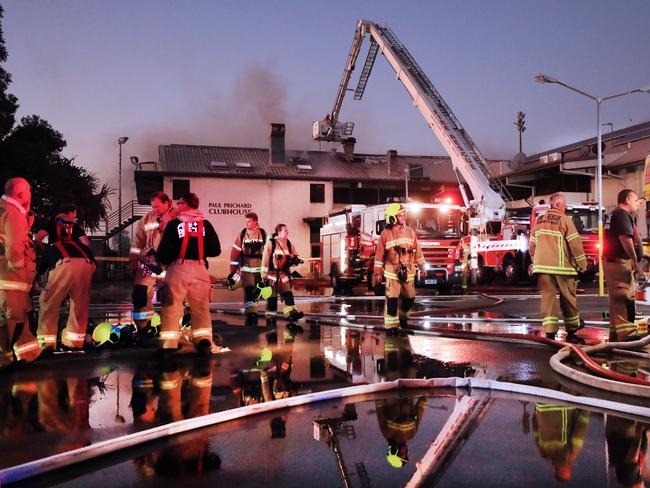 Queensland Fire Brigade Officers and local Kingscliff and Tweed Fire and Rescue officers are caught in the reflection of water that was used to fight the at the Cudgen Leagues Club earlier today.Photo Scott Powick Newscorp