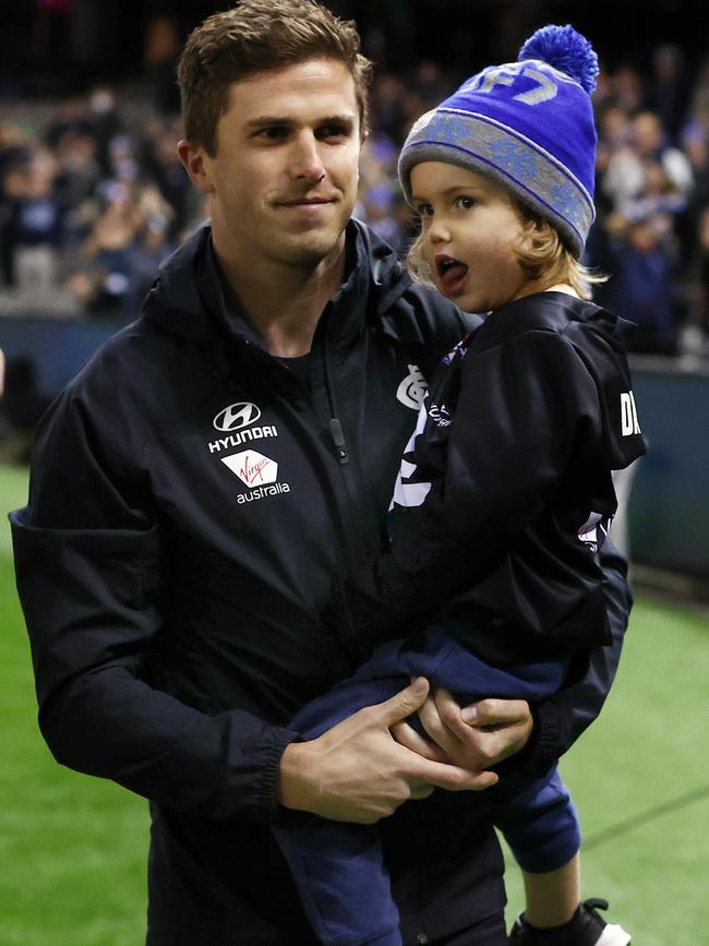 Marc Murphy carries his child after being subbed out with a calf injury. Picture: Michael Klein