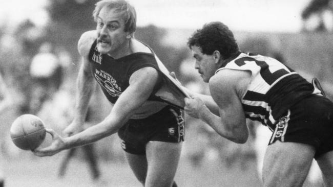 Malcolm Blight gets a handball in despite pressure from Port Adelaide’s Alan Gill at Woodville Oval in 1985. Picture: Stuart Hannagan