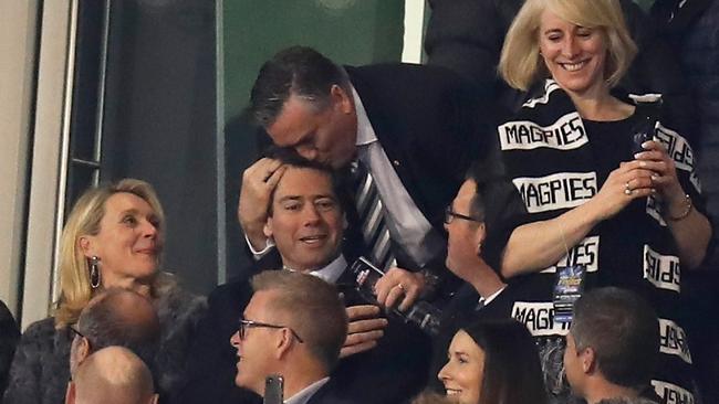 Eddie McGuire kisses Gillon McLachlan on the head at a Collingwood game.