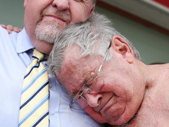 Former councillor Paul Tully comforts flood victim Frank Beaumont after the Supreme Court ruled in favour of over 6000 victims of Queensland's 2011 floods Picture: AAP Image/Jono Searle.