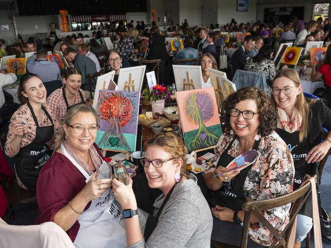 Robertson Scannell team including (front, from left) Stacey Swartz, Brooke Fitzgerald and Penny Bowden take part in the World's Largest Paint and Sip Luncheon for Momentum Mental Health at Clifford Park racecourse, Friday, June 21, 2024. Picture: Kevin Farmer