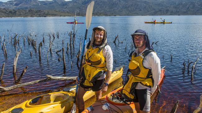 Wild Pedder's Lou Balcombe (left) and Cody McCracken on the shores of Wilmot Island in the middle of SW Tasmania's Lake Pedder with the Frankland Ranges behind them. Photo: Chris Crerar/The Australian