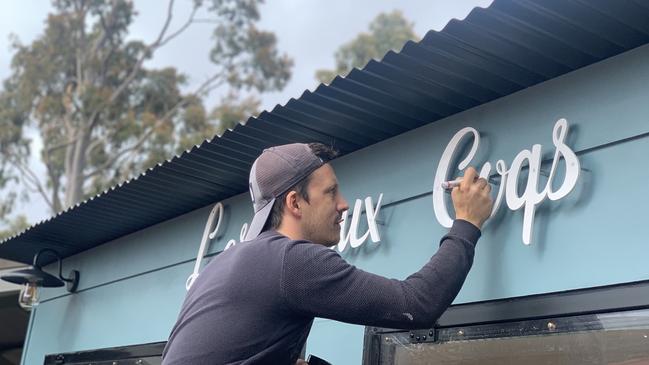 Putting the finishing touches on the new Les Deux Coqs shipping container in Rundle Mall.