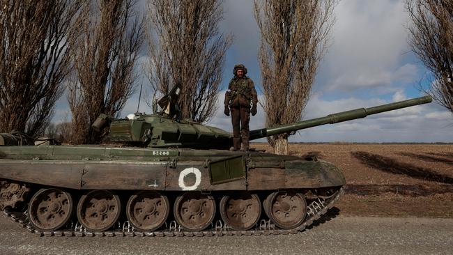 A Ukrainian soldier stands atop a captured Russian T-72 tank. Picture: Reuters