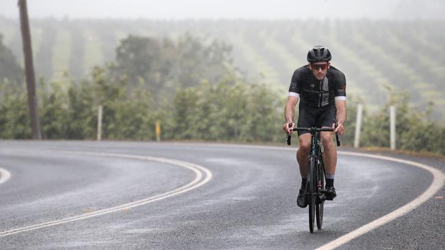 A single cyclist rides into the main street of Yungaburra in the pouring rain during the 2019 Tour of the Tropics. PICTURE: ANNA ROGERS