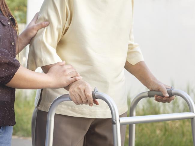 senior woman using a walker with caregiver