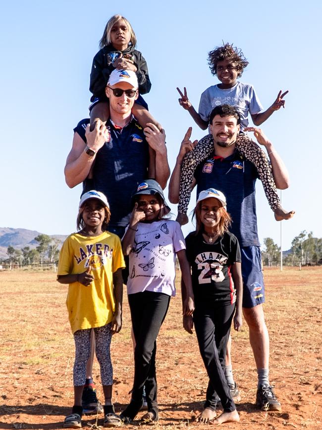 Adelaide’s Izak Rankine and Reilly O’Brien with kids from the APY Lands. Picture: AFC