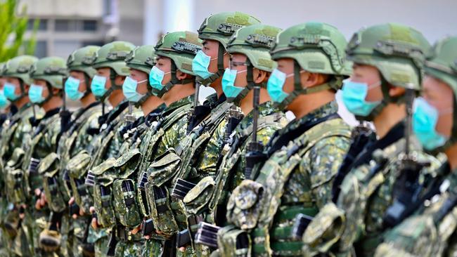 Soldiers wearing face masks amid the COVID-19 coronavirus pandemic listen to an address by Taiwan President Tsai Ing-wen during her visit to a military base in Tainan, southern Taiwan.