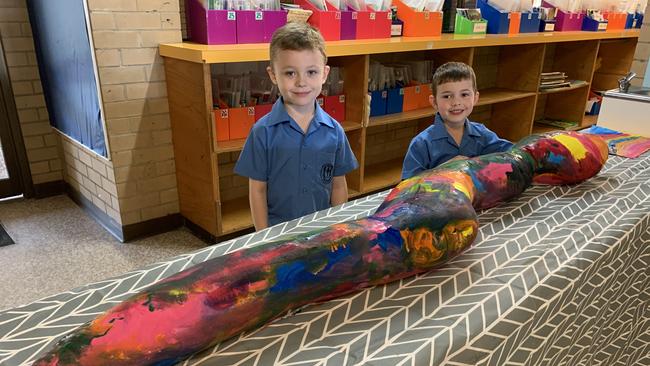 Ethan and Jimmi with the painted rainbow snake painted by the St Joseph's Kindergarten class.