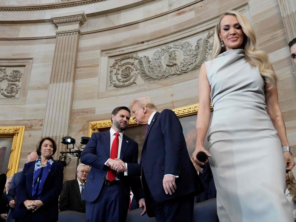 US President Donald Trump shakes hands with Vice President J.D. Vance as singer Carrie Underwood takes the stage to perform America the Beautiful. Picture: AFP