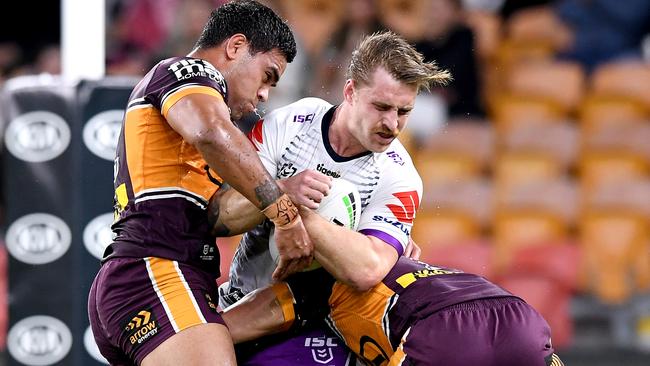 BRISBANE, AUSTRALIA - JULY 24: Cameron Munster of the Storm is tackled during the round 11 NRL match between the Brisbane Broncos and the Melbourne Storm at Suncorp Stadium on July 24, 2020 in Brisbane, Australia. (Photo by Bradley Kanaris/Getty Images)