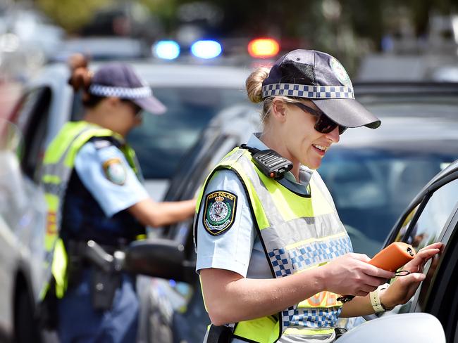 ** WARNING - POLICE OFFICER HAS ASKED FOR NAME NOT TO BE PUBLISHED AS IT MAY JEOPARDISE A FUTURE APPOINTMENT. PLEASE USE GENERIC CAPTION ** Senior Constable Jessica Brooks (R) conducts a breath alcohol test on Matt Salmon during a RBT operation at Terrigal on Tuesday 27th March 2018. Police will be out in force across the Central Coast over the Easter long weekend. (AAP IMAGE / Troy Snook)