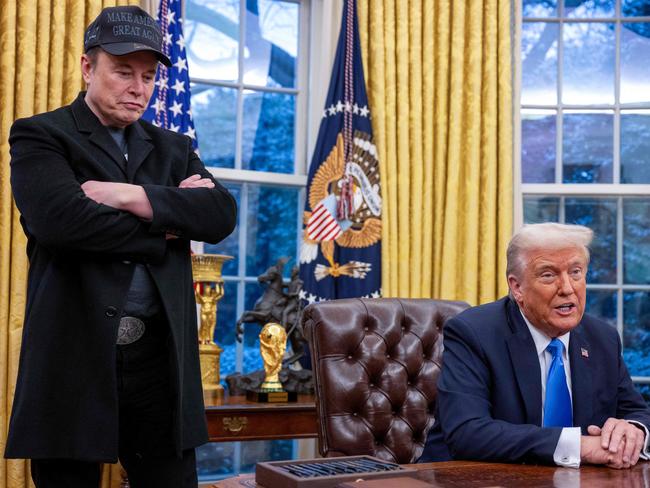 Elon Musk listens as US President Donald Trump speaks in the Oval Office of the White House in Washington, DC, on February 11, 2025. Tech billionaire Elon Musk, who has been tapped by President Donald Trump to lead federal cost-cutting efforts, said the United States would go "bankrupt" without budget cuts. Musk leads the efforts under the newly created Department of Government Efficiency (DOGE), and was speaking at the White House with Trump, who has in recent weeks unleashed a flurry of orders aimed at slashing federal spending. (Photo by Jim WATSON / AFP)