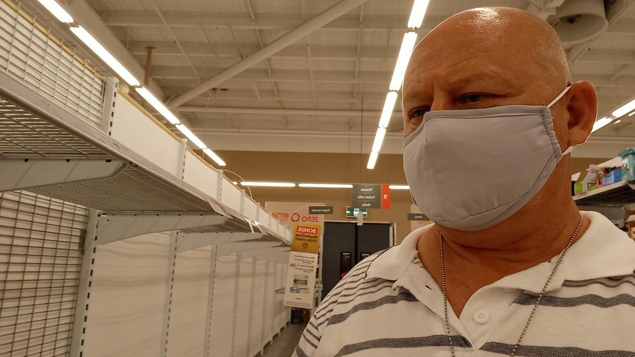 George Helon stares at the empty shelves of a local supermarket.