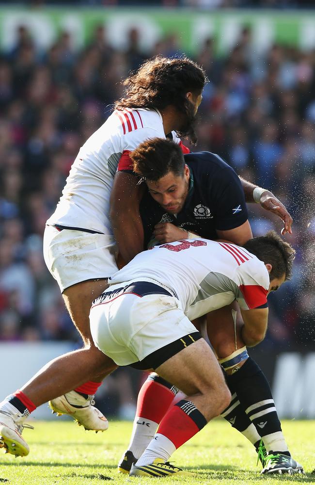 Sean Maitland of Scotland is tackled by Thretton Palamo (L) and Seamus Kelly of the United States.