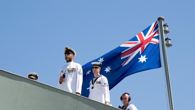 Sailors of the forecastle party of HMAS Success watch the removal of berthing lines as the ship makes final preparations to depart Fleet Base East.