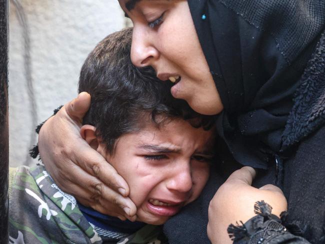 A Palestinian woman and a child cry on February 22, 2024, following overnight Israeli air strikes in Rafah refugee camp in the southern Gaza Strip. Picture: AFP